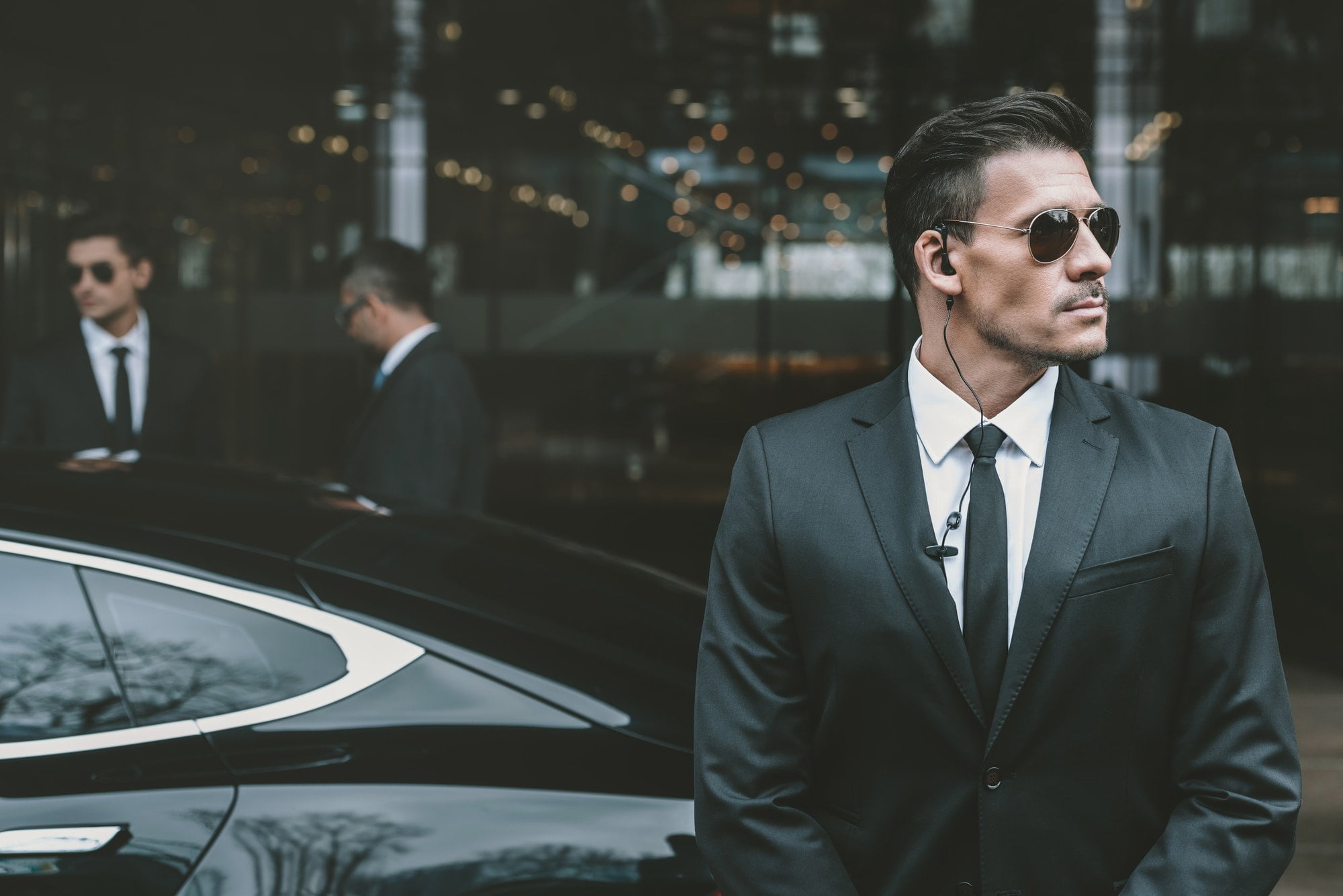 bodyguard-standing-at-businessman-car